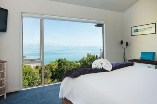a bedroom with a bed and a large window at Selah Retreat in Nelson