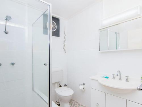 a white bathroom with a toilet and a sink at Forster Holiday Lodge 4 - Central location! in Forster