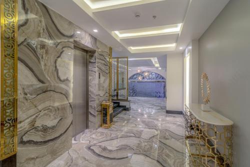 a lobby with a stone wall with a marble floor at South Hotel Suites in Khamis Mushayt
