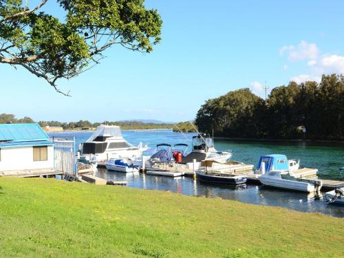 a group of boats docked at a dock on a river at Forster Holiday Lodge 4 - Central location! in Forster