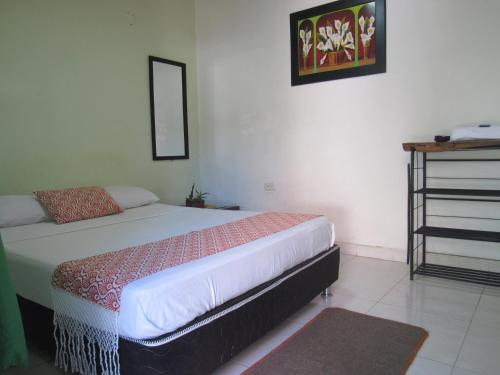 a bedroom with a bed and a dresser in it at Hotel B & C in Mariquita