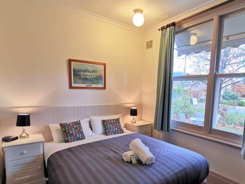 a bedroom with a large bed with two pillows at Elm Lodge Bright in Bright