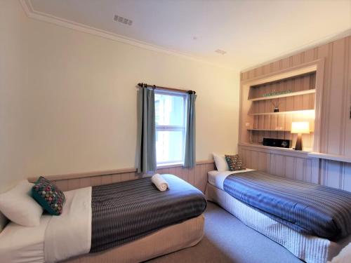a bedroom with two beds and a window at Elm Lodge Bright in Bright
