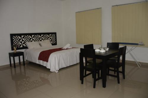 a bedroom with a bed and a table and chairs at Best View Apartments in Nadi