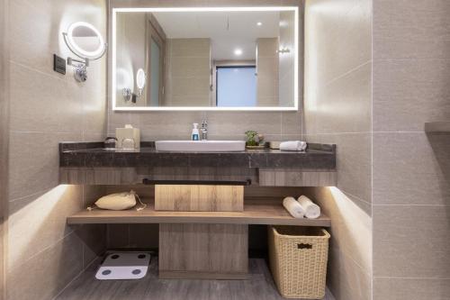 a bathroom with a sink and a mirror at Atour Hotel (Wuhan Mulan Pishang Building) in Huangpi