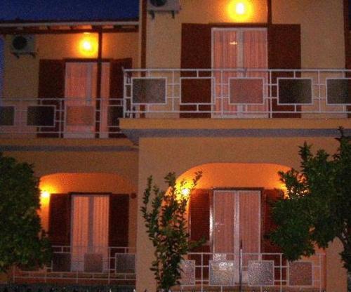 a building with a lit up facade at night at Rantos Apartments in Kavos