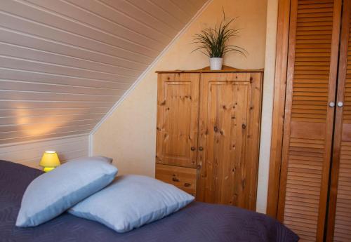a bedroom with a bed and a wooden cabinet at Strandhaus Nr. 9 OG re. in Dahme