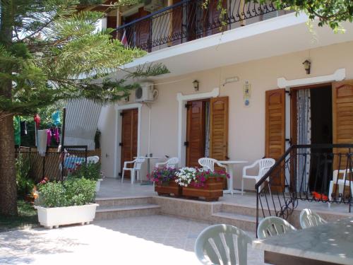 a patio of a house with chairs and tables at Villa Xenos in Kalamaki