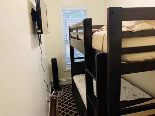 Pokój z 2 łóżkami piętrowymi i telewizorem w obiekcie Rochester's Place w mieście Brooklyn