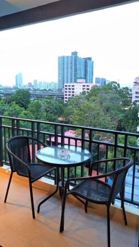 a table and two chairs on a balcony at Amp Am House Bangkok Hotel in Bangkok