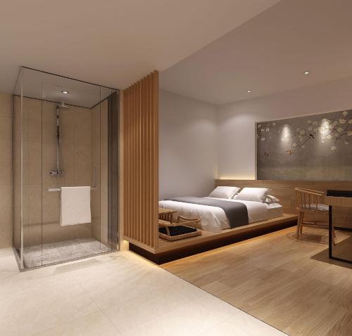 a bedroom with a bed and a glass shower at Dashen Hotel Shunde Lecong in Shunde
