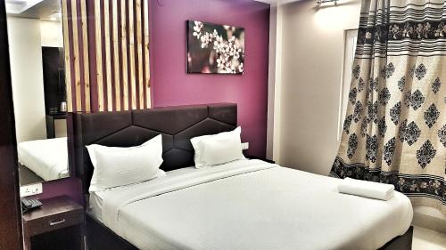 a bedroom with two beds and a purple wall at Airport Hotel Delhi Aerocity, Near Yashobhoomi in New Delhi
