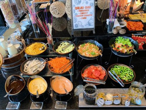 a buffet filled with different types of food in bowls at SKYVIEW Hotel Bangkok - Sukhumvit in Bangkok
