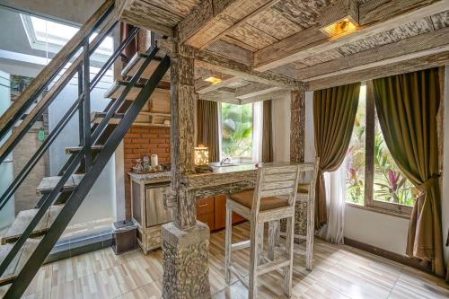 a room with a staircase and a table with a chair at KTS Balinese Villas in Canggu