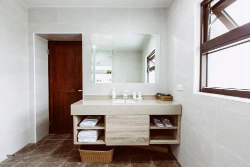uma casa de banho com um lavatório e um espelho em 貝富門旅館 - 澎湖灣行旅 em Magong