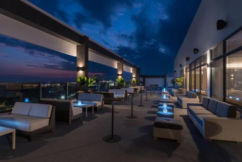 a rooftop patio with couches and tables at night at Seda Capitol Central Hotel in Bacolod