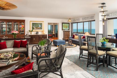 a living room with a couch and tables and chairs at Anantara Hua Hin Resort in Hua Hin
