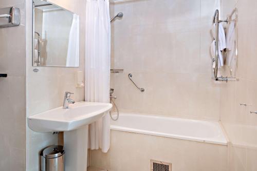 a white bathroom with a sink and a bath tub at Center Hotel - Sure Hotel by Best Western in Gothenburg