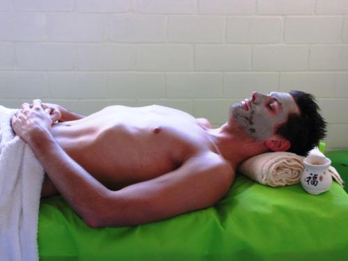 a shirtless man laying on a green bed at Best Western PLUS Plaza Florida & Tower in Irapuato