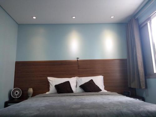 um quarto com uma cama grande e uma cabeceira em madeira em Apartamento Santana Expo Center Norte vista Top cidade de São Paulo e Paulista em São Paulo