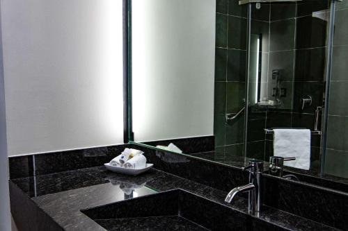 a bathroom with a sink and a mirror at Comfort Inn Irapuato in Irapuato