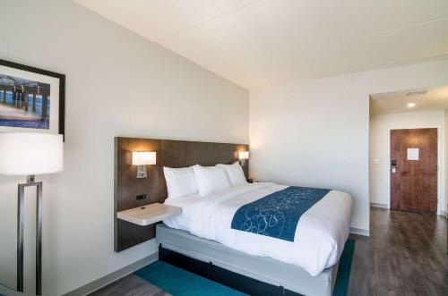a bedroom with a large bed and a lamp at Comfort Inn & Suites Gulf Shores East Beach near Gulf State Park in Gulf Shores