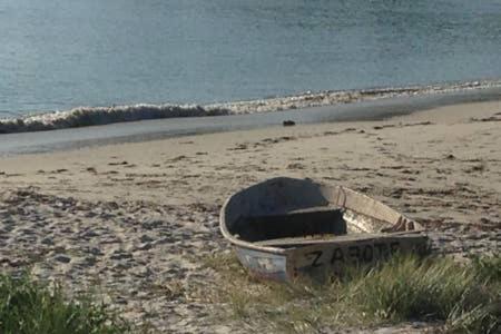 a boat sitting on a beach near the water at Broughton Views in Corlette