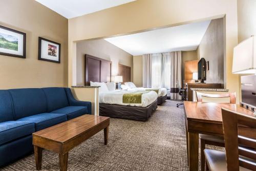 a hotel room with a bed and a couch at Comfort Suites Sioux Falls Mall District in Sioux Falls