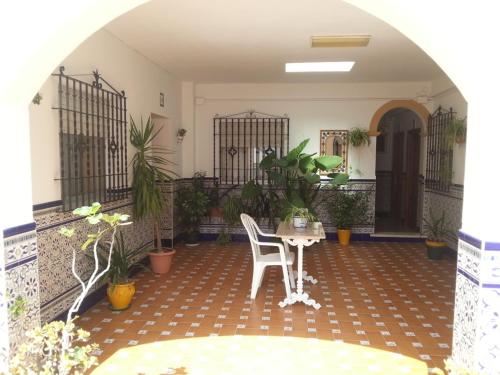 a patio with a table and chairs and plants at Hostal Málaga in Arcos de la Frontera