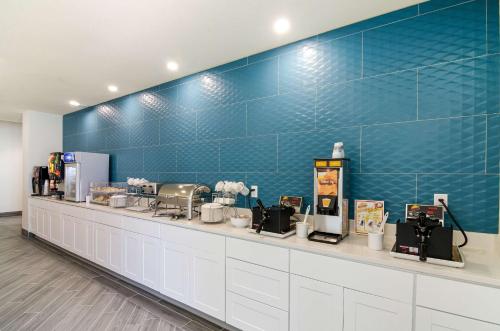 a counter in a store with a blue tiled wall at Comfort Inn & Suites Gulf Shores East Beach near Gulf State Park in Gulf Shores