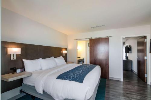 a hotel room with a large bed and a bathroom at Comfort Inn & Suites Gulf Shores East Beach near Gulf State Park in Gulf Shores