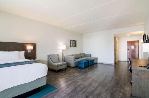 a hotel room with a bed and a couch at Comfort Inn & Suites Gulf Shores East Beach near Gulf State Park in Gulf Shores