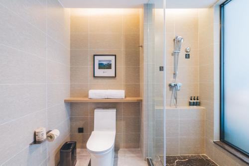 a bathroom with a toilet and a shower at Atour Hotel Taizhou Linhai Branch in Linhai