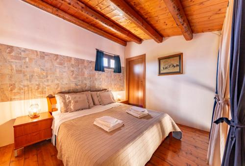 una camera da letto con un letto e un soffitto in legno di Valle Degli Dei AgriResort a Noto