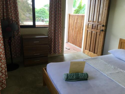 a room with a bed with a sign on it at John Verhel Homes in Panglao