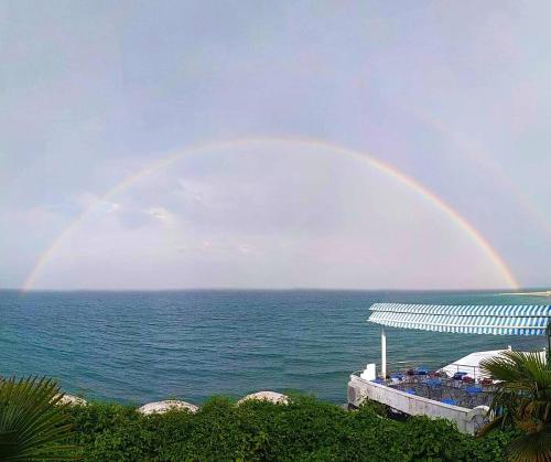 a rainbow in the sky over the ocean at Olympos Beach in Plaka Litochorou