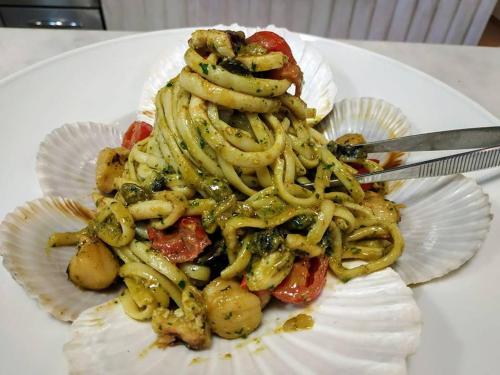 a pasta dish on a white plate with a fork at Olympos Beach in Plaka Litochorou