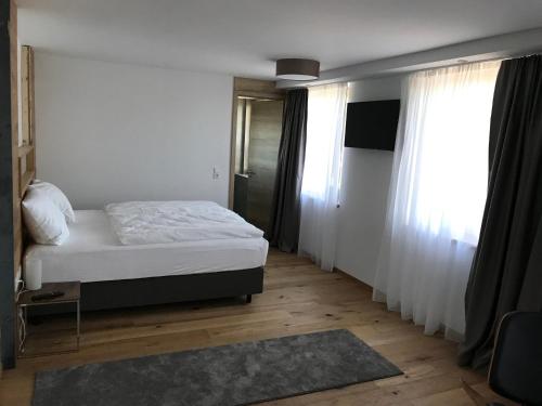a bedroom with a bed and two windows at Kallido in Hermeskeil