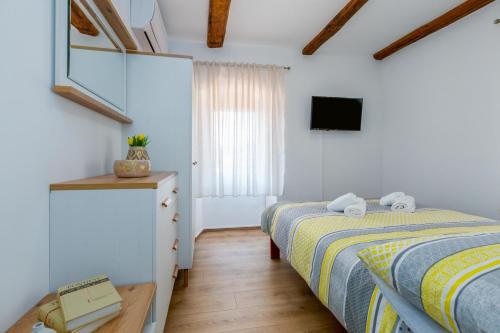 una camera con 2 letti singoli e una TV di Kuća za odmor Aurora a Kavran
