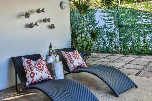 two chairs on a patio with birds on the wall at Kingsley House Chalet in Ballito