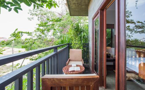 a balcony of a house with a chair and a table at Won Residence & Spa in Siem Reap