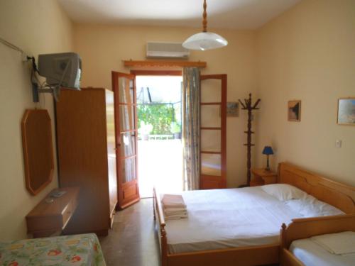 a bedroom with a bed and a sliding glass door at Villa Xenos in Kalamaki