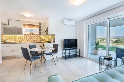 a kitchen and living room with a table and chairs at Villa Oasis in Galatás