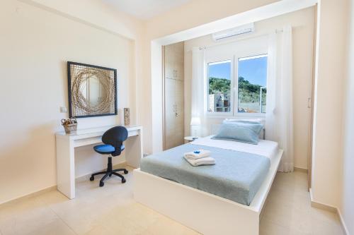 a bedroom with a bed and a desk and a window at Villa Oasis in Galatás