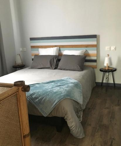 une chambre avec un grand lit avec une tête de lit en bois dans l'établissement Chalet Camélia Bayeux centre-ville, à Bayeux
