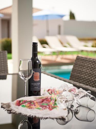 a bottle of wine and glasses on a table at Angie Luxury Beach Villas in Ayia Napa