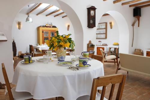 a white table with a vase of flowers on it at Monte das Cortelhas in Guia