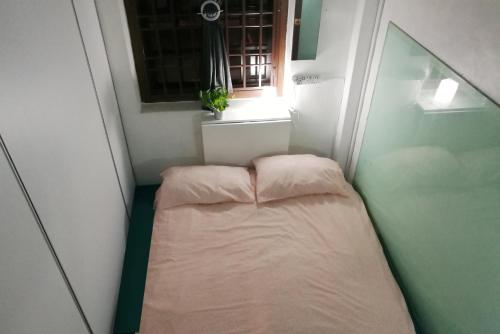 怡保的住宿－EDM旅舍，一个小房间的小床,设有窗户