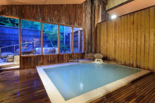 a large pool of water in a room with windows at Meitoya So in Zao Onsen