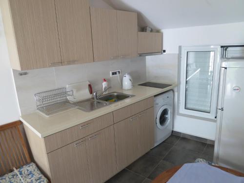a kitchen with a sink and a washing machine at Reževići Apartments in Petrovac na Moru